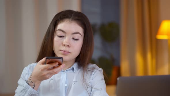 Young Asian Woman Sitting at Home and Scanning Qr Code on Receipt with Smartphone App alt