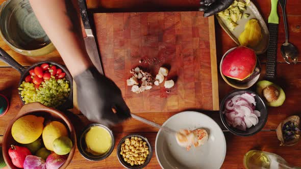 Straight down view of a professional chef cutting and slicing octopus tentacle, scallops and prawns alt