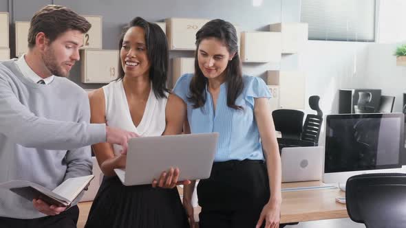 Business colleagues discussing over laptop 4k alt