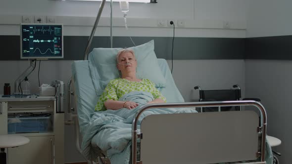 Portrait of Old Woman Sitting in Hospital Ward Bed to Cure Disease alt