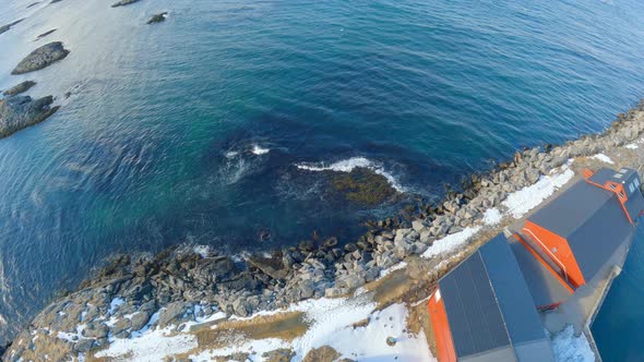 High angel view from Andenes Lighthouse towards the ocean, waves breaking on the shoreline, Norway. alt