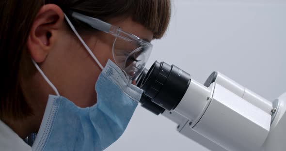 Crop View of Young Medical Female Worker Looking To Microscope alt