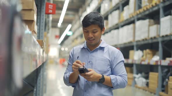 Man worker checking products with barcode scanner in warehouse.