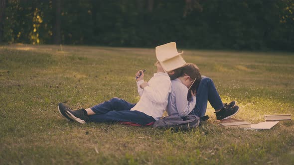 Boys Have Fun with Textbooks Preparing for Exams in Park alt