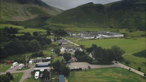 Scottish Arran Whiskey Distillery Aerial View Along Road in Greenery Valley with Mountains in Summer