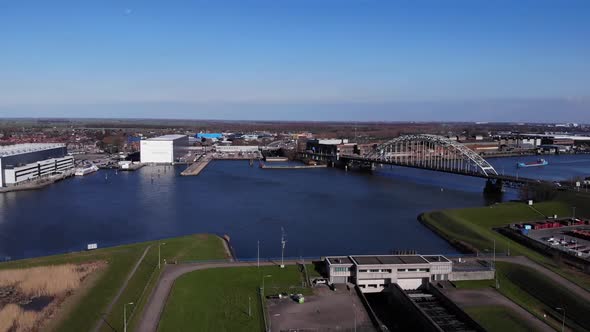 Aerial View Of Arch Bridge Spanning  At Noord River With Blue Sky In the Background. alt