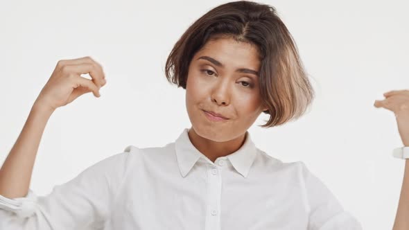 Young Beautiful Brunette East Asian Female in Shirt Actively Surprising and Showing Ok on White alt