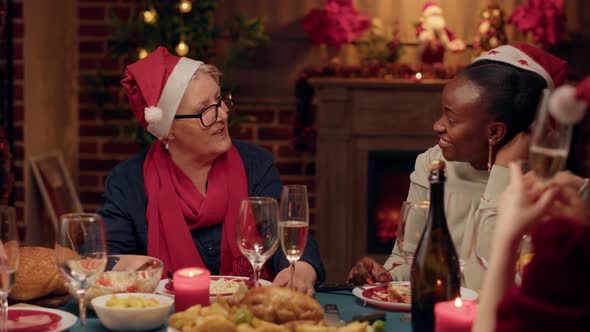 Senior Woman Talking with Festive Young Adult Person While Enjoying Christmas Dinner at Home alt