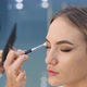 Young Brunette Woman Makeup Artist Paints a Blonde Girl in a Beauty Salon Eyeshadows