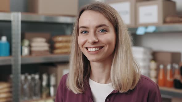 Portrait of Woman in Casual Wear Posing Among Food Bank alt