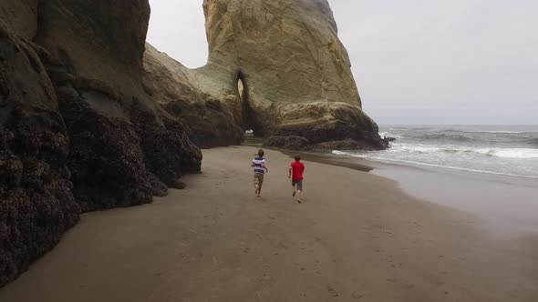 Two boys running on beach alt