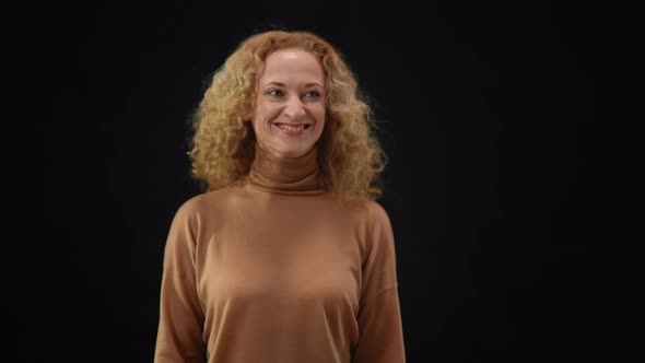 Positive Smiling Woman Walking to Camera in Flashes Holding Hand on Chest Thanking Reporters at News alt