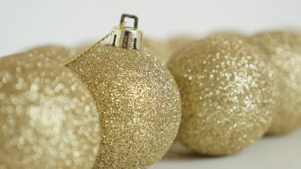 Slow tilt on golden Christmas bauble close-up 4K video alt