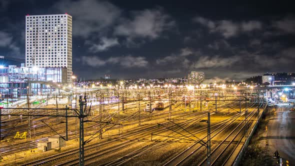 Railway tracks and modern office building at night Time Lapse