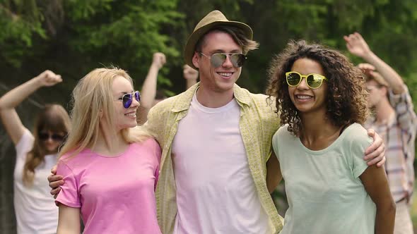 Happy Young Man Dancing With Two Beautiful Women at Outdoor Party, Summer Flirt alt