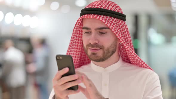Portrait of Serious Arab Businessman Using Smartphone alt