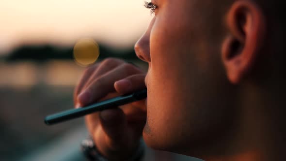 Guy Smokes an Electronic Cigarette Close-up