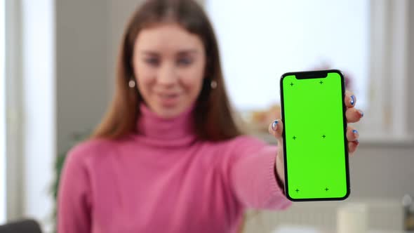 Web Mockup Green Screen Smartphone in Hand of Blurred Satisfied Woman Smiling at Background alt