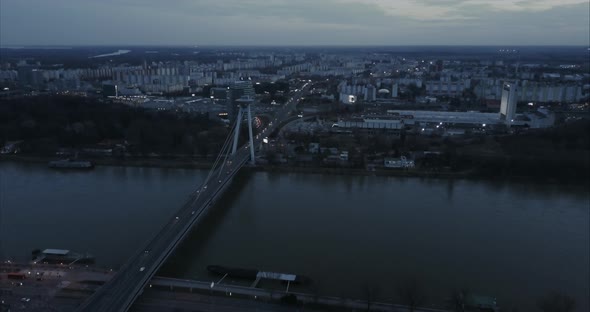 Slow Descending Wide Aerial shot of SNP Bridge and Petrzalka in Bratislava at twilight alt
