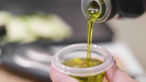 Pouring Olive Oil into a Cup