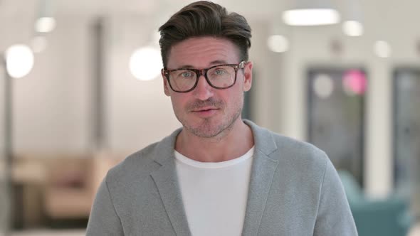 Portrait of Middle Aged Man Waving on Video Call alt