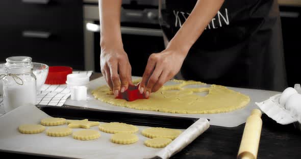 Woman Puts Shortbread Cookies on a Baking Tray alt