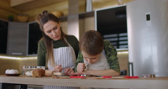 Young Mother and Son Cooking Cookies Together in the Kitchen alt