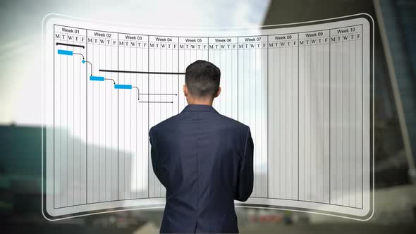 Businessman Looks to Gantt Chart, Project Schedule Harmonogram Work Processes alt