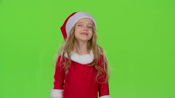 Kid in a Red Suit Are Standing in the Room and Wink. Green Screen alt