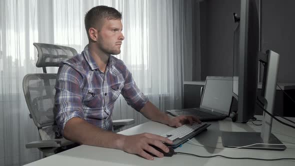 Handsome IT Office Worker Using Two Computers Working on a Project alt