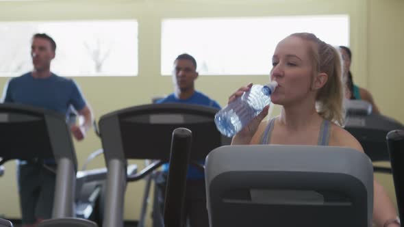 Woman taking drink of water at gym