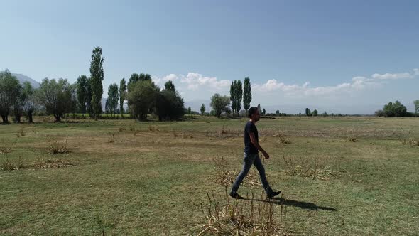 Young Man Walking Alone At Countryside alt