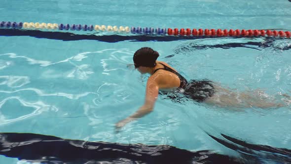 Female Amateur Swimmer Doing Breaststroke In Swimming Pool