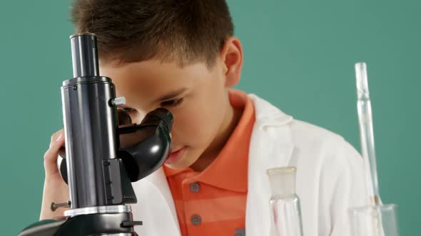 Schoolboy looking through microscope in laboratory 4k alt