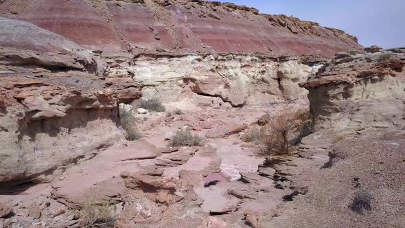 Slowly flying through desert canyon over sharp rocks alt