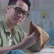 Close Up Of Asian Man Designer With Layout Bond Looking At The Fabric In Hands - VideoHive Item for Sale
