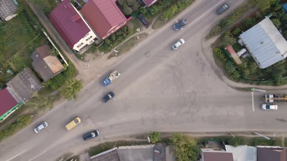 Aerial View of a City Intersection with Moving Cars and Onestory Houses alt