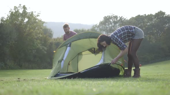 Couple assembling dome tent on camping trip