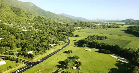 Aerial view of motorway going through the hills and grassland. alt