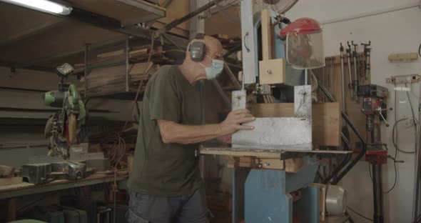 Wood worker works a saw machine