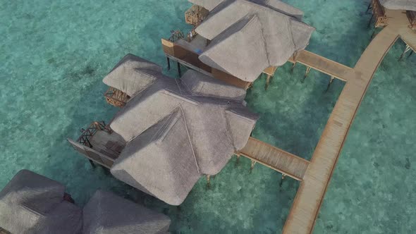 Aerial view of luxury bungalows on water, Island resort villas above sea. Maldives from drone