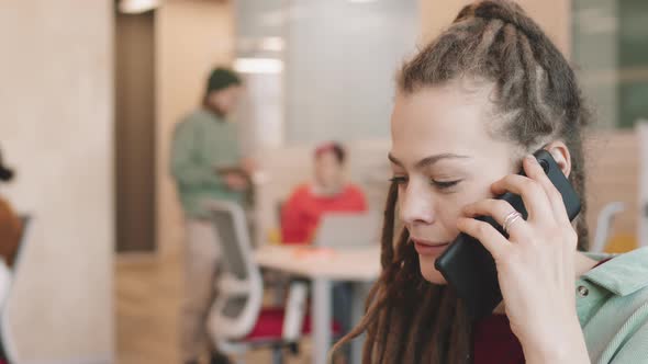 Businesswoman in Dreadlocks Talking on Mobile Phone alt