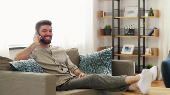 Happy Man Calling on Smartphone at Home alt