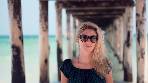 Dreamy Woman Smiling And Relaxing On Beach. Stress Free Girl In Summertime Season Sundress Leisure. alt