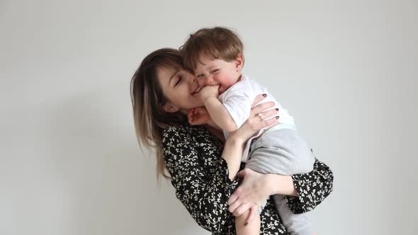 Mother with son on white wall background in home