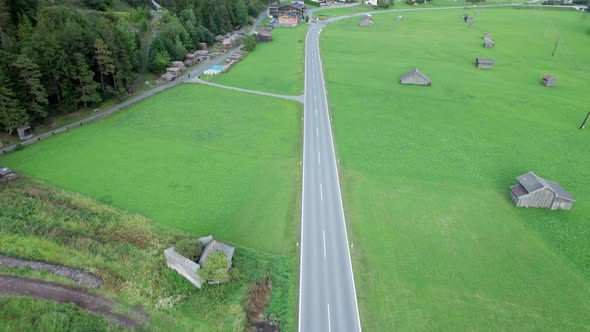 Road in Austria Between Green Fields In an Alpine Village Aerial View alt