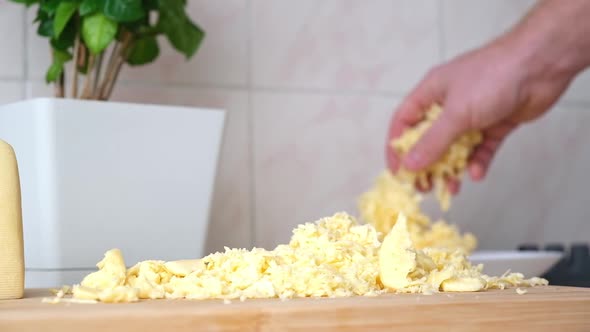 A Man Rubs Cheese on Metal Grater for Freezing and Further Cooking Pizza Pasta