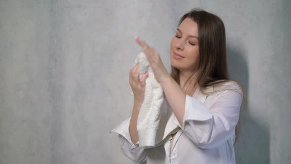 A Young Housewife Woman Takes a Stack of Fresh Washed Clean Linen in Her Hands