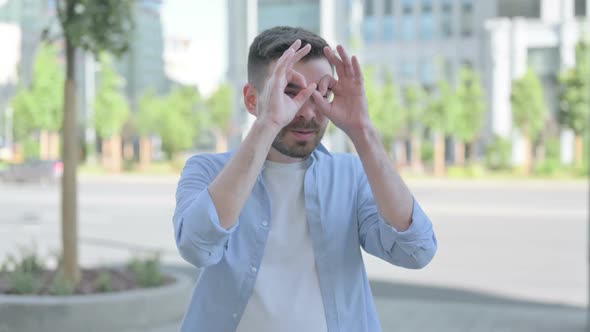 Outdoor Young Man Searching with Handmade Binocular alt