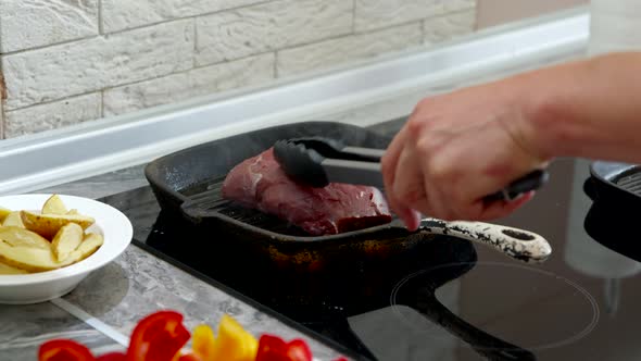 Close Up Putting Juicy Piece of Steak Beef in Grill Pan. Cooking Meat Meal